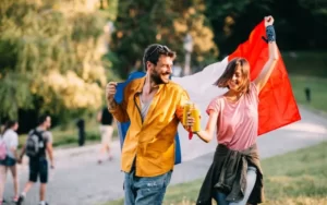 Jovem casal dançando em um festival no parque com uma bandeira da França